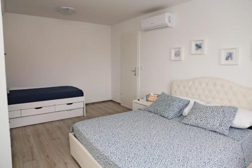 a white bedroom with a bed and a dresser at NEW LUXURY APARTMENT SANDRA- OLD TOWN KORCULA in Korčula