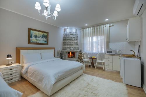 a bedroom with a bed and a kitchen with a fireplace at Vila 1 in Korçë