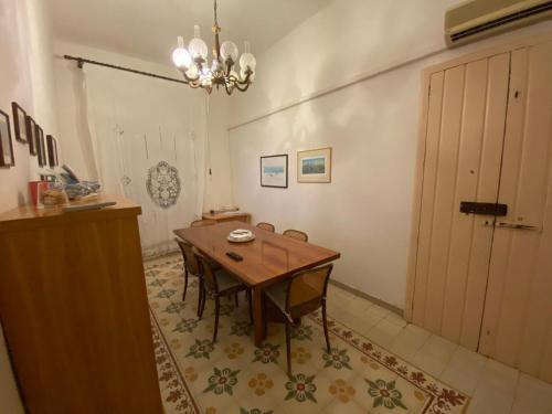 una sala da pranzo con tavolo, sedie e lampadario pendente di Casa Diroma a Ginosa Marina