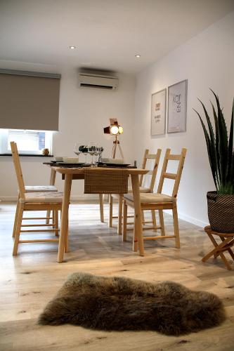 a dining room with a wooden table with chairs and a fur rug at Appart Aldyis in Sprimont