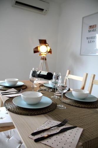 a table with plates and wine glasses on it at Appart Aldyis in Sprimont