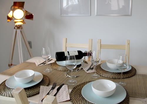 a table with plates and wine glasses on it at Appart Aldyis in Sprimont