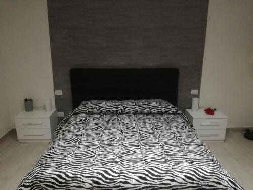 a bed with a black and white comforter in a bedroom at IL MELOGRANO HOLIDAY COMO in Como