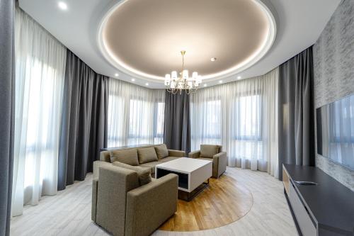 a living room with a couch and a table and windows at Hilltop North Avenue by Stellar Hotels, Yerevan in Yerevan
