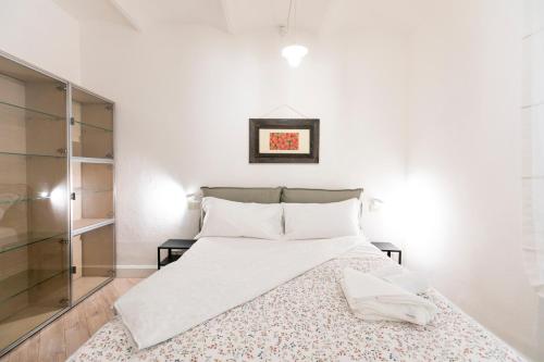 a white bedroom with a bed and a glass cabinet at Saragozza Apartments - Bologna Short Rental in Bologna