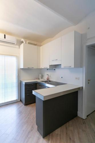 an empty kitchen with white cabinets and a sink at Saragozza Apartments - Bologna Short Rental in Bologna