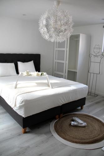 a bedroom with a large bed with a chandelier at Appartement Blanc cocooning in Sprimont
