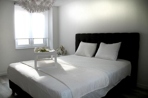 um quarto com uma cama com uma mesa de cabeceira em Appartement Blanc cocooning em Sprimont