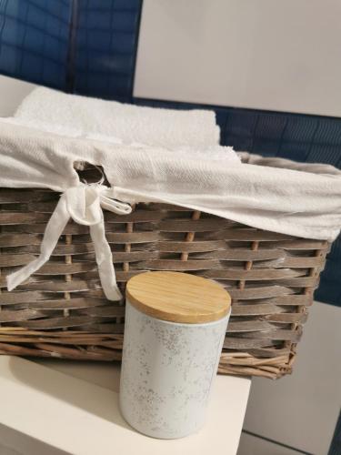 a basket with a white towel and a cup at Chic Apartment in Brăila