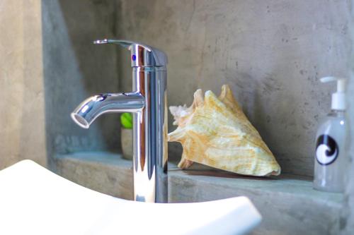 a bathroom sink with a faucet and a n at Casa de Olas Boutique Hotel in Puerto Escondido