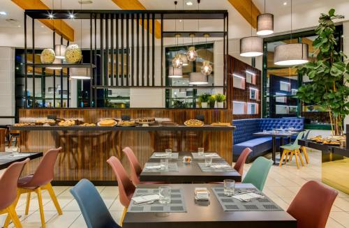 a restaurant with tables and chairs and a bar at Holiday Inn Bologna - Fiera by IHG in Bologna