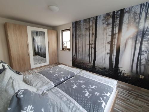 Dormitorio con cama y pared con posters en Ferienwohnung "Waldzauber" en Bärenstein