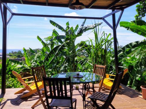 a patio with a table and chairs on a deck at Chalet cabane in Capesterre-Belle-Eau