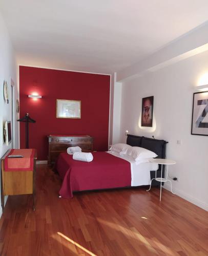 a bedroom with a bed with a red wall at Penta Luxury Room in Matera