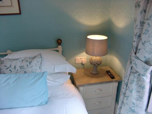 a bedroom with a bed and a lamp on a night stand at Osborne House B&B Workington in Workington