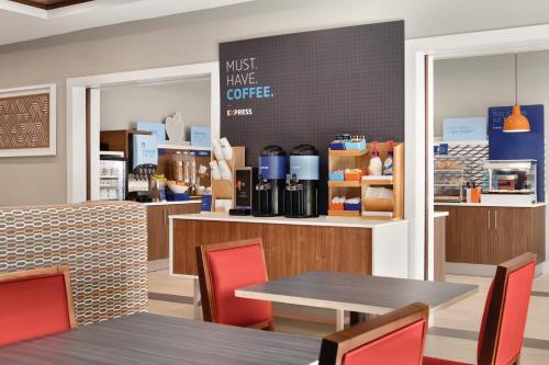 a restaurant with tables and chairs and a counter at Holiday Inn Express Hotel & Suites Lavonia by IHG in Lavonia