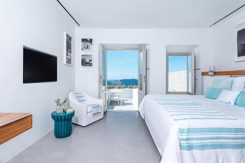 a white bedroom with a large bed and a flat screen tv at Grace Hotel, Auberge Collection in Imerovigli