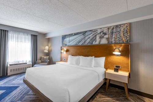 a hotel room with a large bed and a chair at Comfort Inn in Sarnia