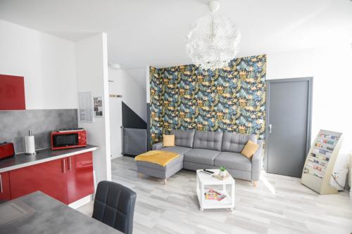 Appartement "le Terminus " Gare-Cosy-Wifi 6 Personnes في سانت كونتان: غرفة معيشة مع أريكة رمادية ومطبخ