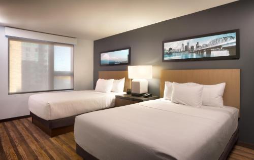 a hotel room with two beds and two windows at Hyatt House LA - University Medical Center in Los Angeles