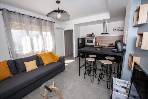 a living room with a couch and a kitchen at Explore the World 1 in Perpignan