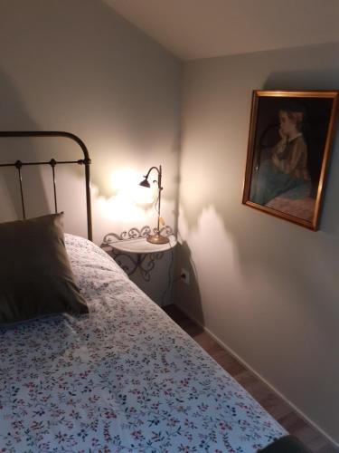 a bedroom with a bed and a picture on the wall at la grange aux oiseaux in Arnaville