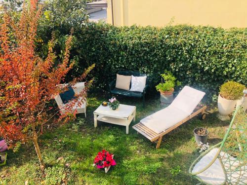 a garden with two chairs and a table and a hedge at Casa Matì in Altedo