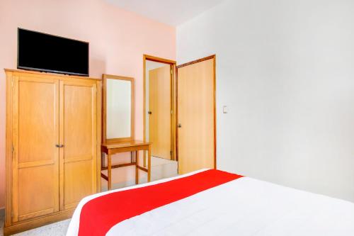 a bedroom with a bed and a flat screen tv at Hotel La Estancia in Colima