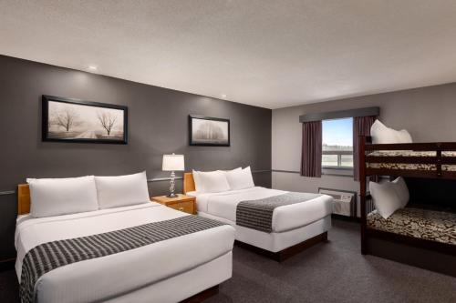 a hotel room with two beds and a balcony at Travelodge by Wyndham Brandon in Brandon