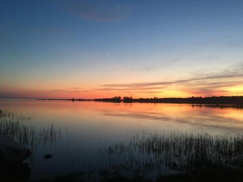 a view of a lake at sunset at Secret Beach House off-grid, sauna and outdoor WC in Muriste