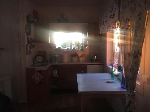 a kitchen with a light shining through a window at Secret Beach House off-grid, sauna and outdoor WC in Muriste