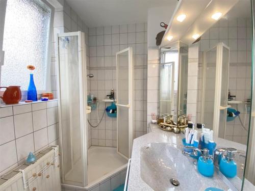 a white bathroom with a sink and a shower at Baden-BadenSpaApartment in Baden-Baden