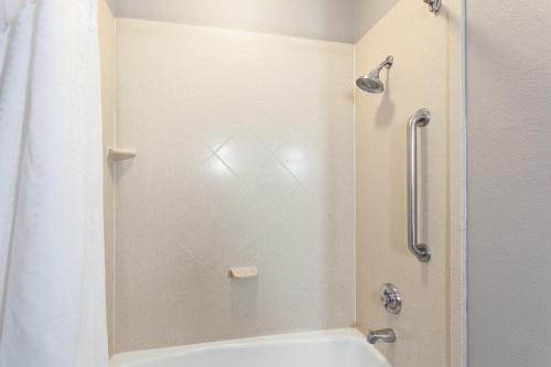 a bathroom with a shower and a white tub at Holiday Inn Express & Suites Wharton, an IHG Hotel in Wharton