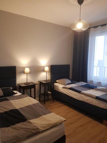 a bedroom with two beds and two tables with lamps at Sun Apartment Katowice Chorzów in Katowice