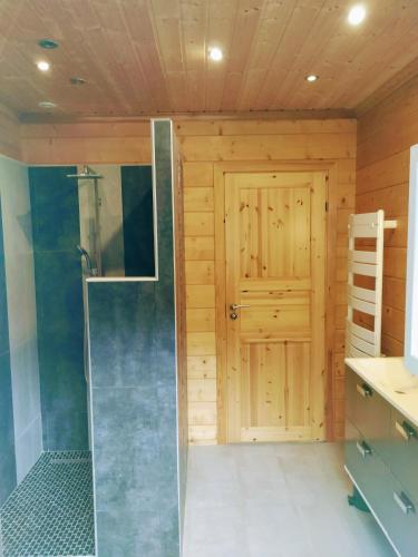 a bathroom with a shower and a door at Insolite maison bois, wifi, streaming au coeur de l'Argonne et des batailles de Verdun in Chaudefontaine