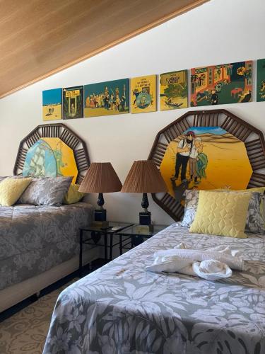 a bedroom with two beds and posters on the wall at Flor de Limão Hotel Boutique in Coroa Vermelha