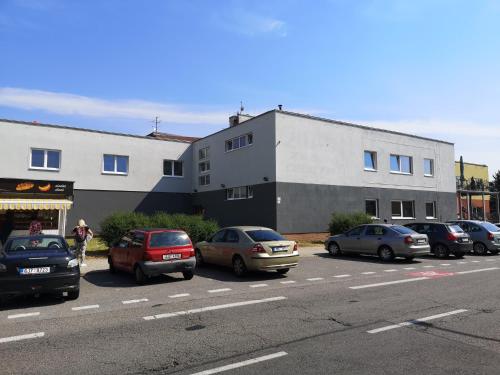 a parking lot with cars parked in front of a building at Penzion DON in Třebíč