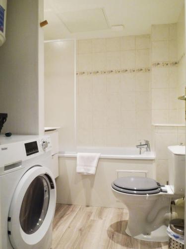 une salle de bain avec machine à laver et toilettes dans l'établissement Les Cosy de Nancy - Le repère du roi stanislas 4étoiles, à Nancy