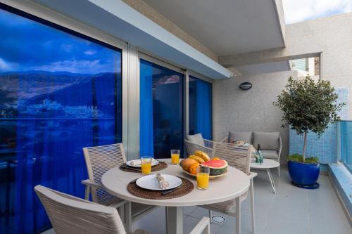 a white table with food on it on a balcony at Sunny Valley Apartment in Mogán
