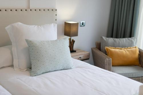 a bedroom with a bed with a pillow and a chair at Sunny Valley Apartment in Mogán
