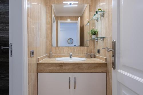a bathroom with a sink and a mirror at Sunny Valley Apartment in Mogán