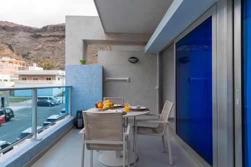 a room with a table and chairs on a balcony at Sunny Valley Apartment in Mogán