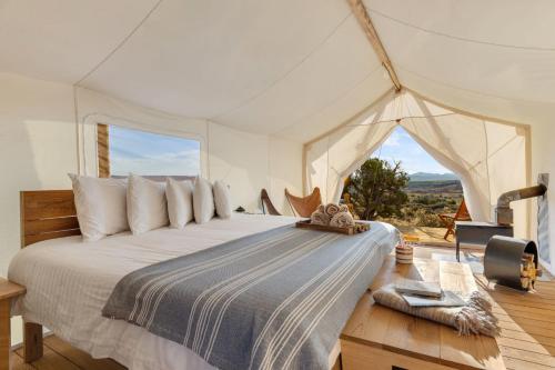 En eller flere senge i et værelse på Under Canvas Moab