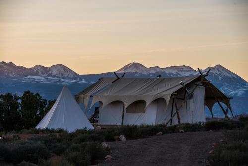 a tent with a mountain in the background at Under Canvas Moab in Moab