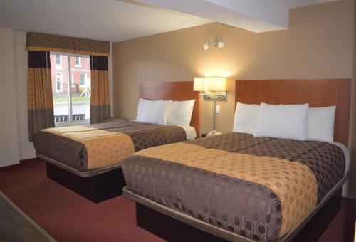 a hotel room with two beds and a window at Knights Inn Arnprior in Arnprior
