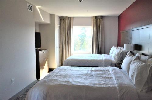 a hotel room with two beds and a window at Staybridge Suites - Orenco Station by IHG in Hillsboro
