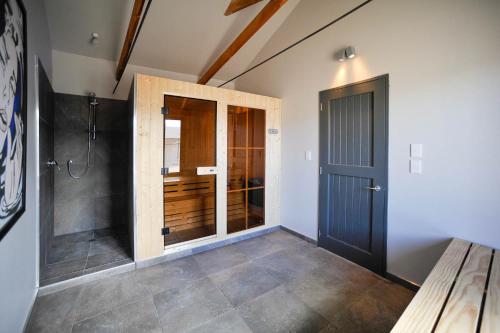 a bathroom with a walk in shower next to a door at Windhover Suites in Tasman