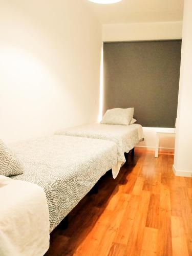 two beds in a room with a chalkboard on the wall at TOLETUM low cost LOFTS diáfanos o 2dormitorios PARKING Municipal Gratis al aire libre a 100m in Toledo