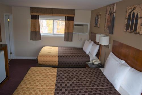a hotel room with two beds and a window at Knights Inn Arnprior in Arnprior