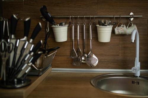 a kitchen counter with utensils on a wall next to a sink at Milmari MINART S40 in Kopaonik